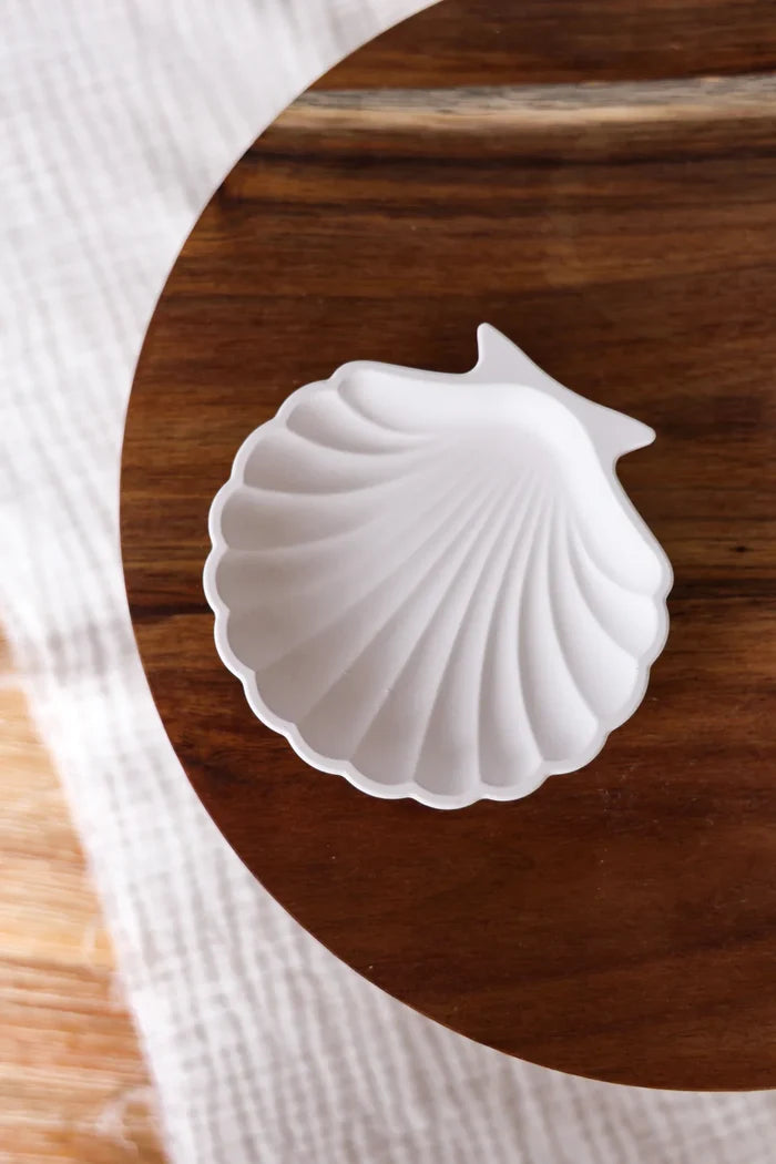 White shell-shaped ceramic on a wooden surface
