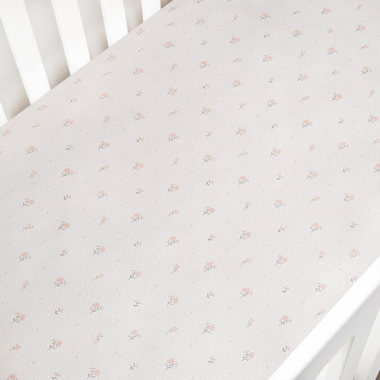 Floral patterned crib sheet on a white crib