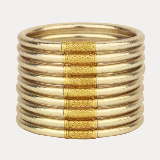 Stack of gold bangles on a white background