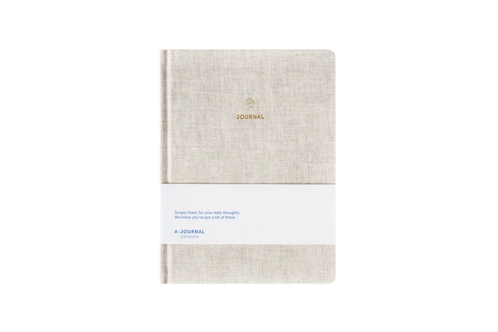 Beige linen hard cover journal on a white background