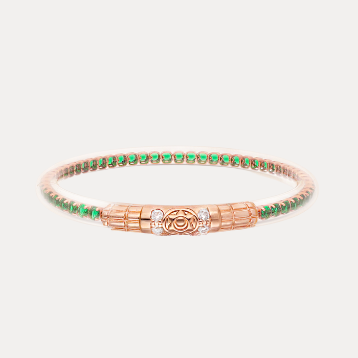 a gold bracelet with green and white stones