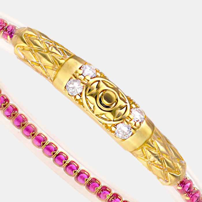 a gold bracelet with pink and white stones