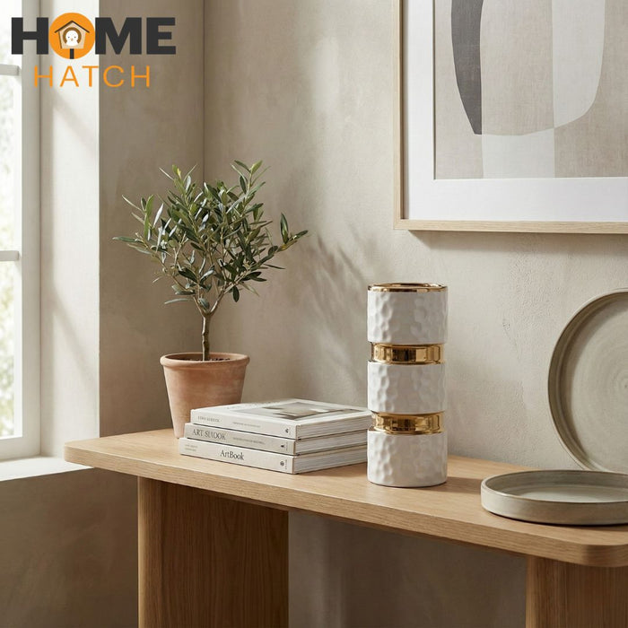 White textured ceramic vase with gold metallic accents on a clean background
