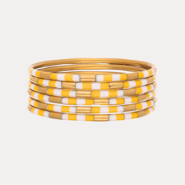 a stack of yellow and white bracelets